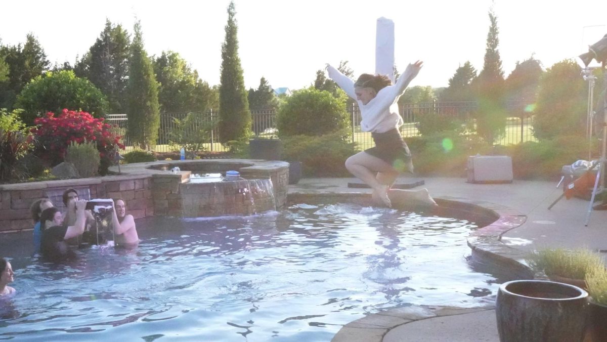 One of the stars featured in "Eventually," a music video directed by digital cinema production major Parker Finks, leaps into the pool, as the audience watches in wonder at the recent capstone film screening hosted by the DCP department.