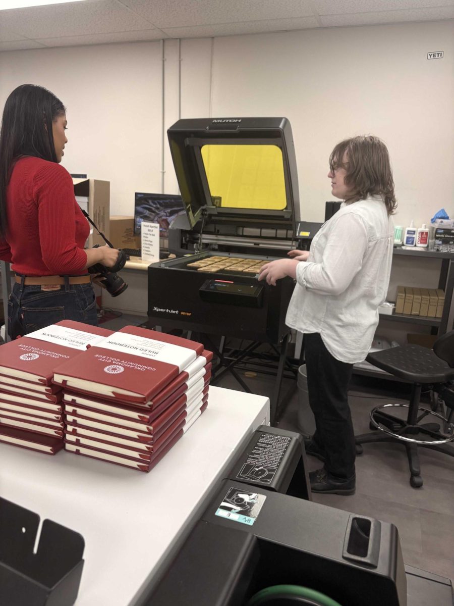 Silver Wakefield (right), a technician at the OCCC Print Shop, showcases some of the high-end equipment utilized by the department during a recent open house hosted by the Print Shop staff.
