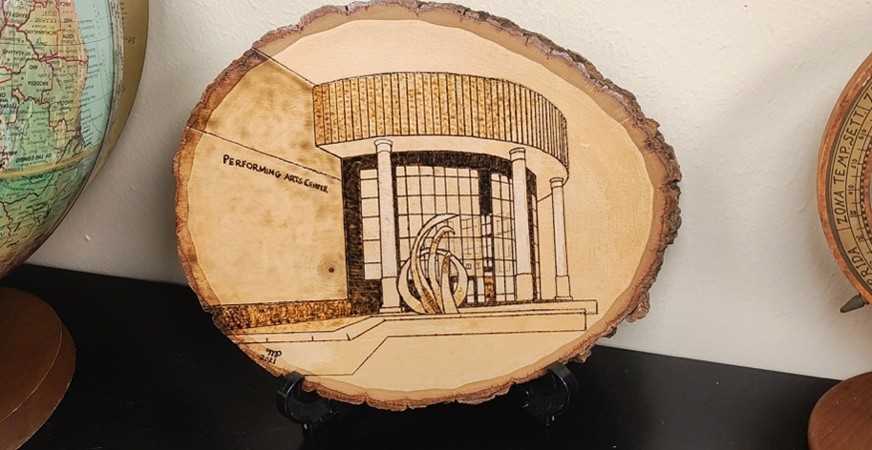 A wood-burning piece submitted to the Absolute by a former nursing student has found a permanent home in the office of Chair of English Jeff Provine, who serves as the faculty advisor for the campus literary and artistic journal.