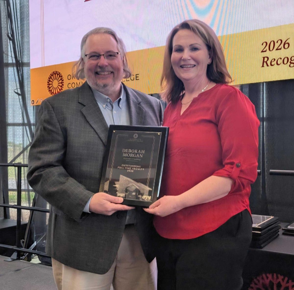 Dean of Social Sciences Jason Hall presents the division's Outstanding Full-Time Faculty Award to Professor of Sociology Deborah Morgan at the annual awards luncheon hosted by Academic Affairs near the end of the spring semester.