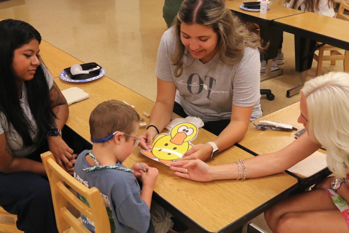 OCCC students guide a young boy through an exercise designed to teach him about colors, numbers and animals at a recent training camp for future therapy assistants.